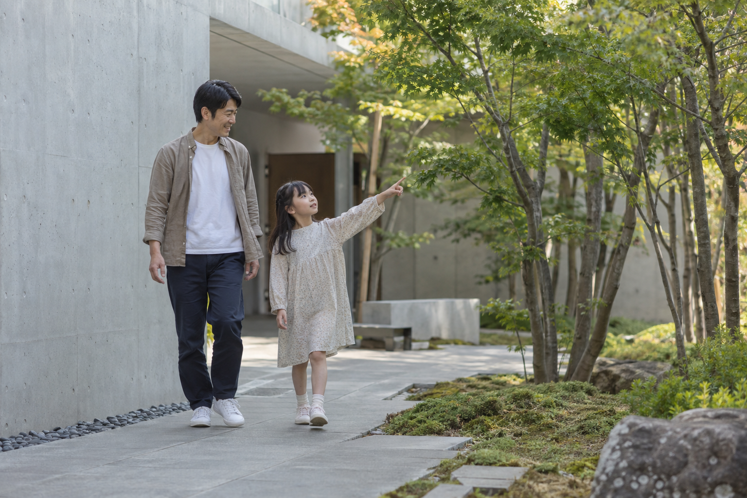 緑と石の中庭で、子供と父親が一緒に歩くイメージ